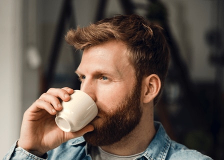 Mand drikker en kop kaffe